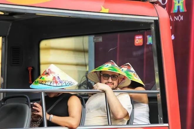 Les touristes étrangers visitent le vieux quartier de Hanoï en voiture électrique. Photo: VNA du lich 1.webp