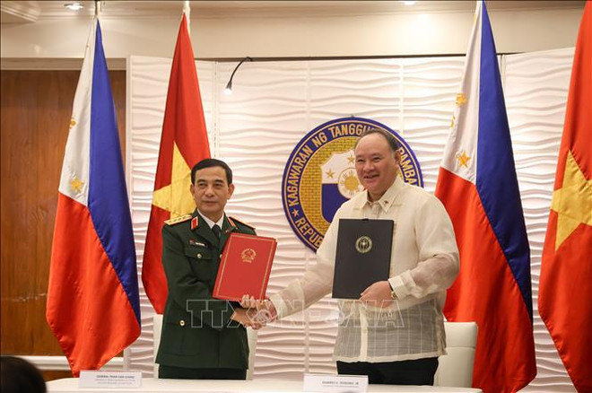 Phan Van Giang (gauche) et Gilberto Teodoro ont assisté à la signature de la Lettre d'intention entre les deux ministères de la Défense sur le renforcement de la coopération dans le domaine de l'assistance humanitaire et des secours en cas de catastrophe maritime. Photo : VNA lettre.jpg