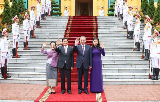 Le secrétaire général du PCV et président To Lam (2e de droite à gauche) et son épouse et le secrétaire général du PPRL et président lao Thongloun Sisoulith et son épouse lors de la cérémonie d'accueil. Photo: VNA don 2.jpg