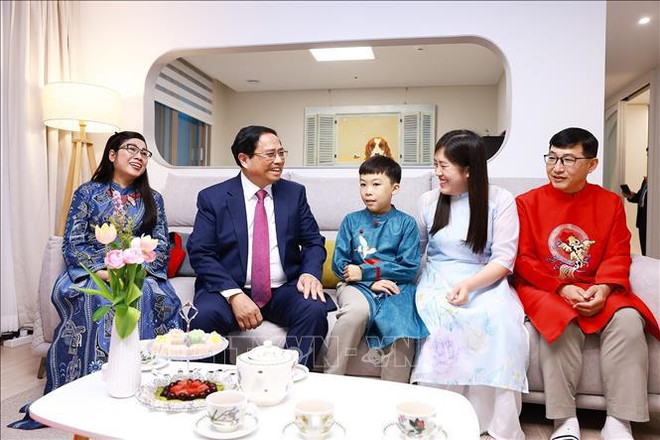 Le Premier ministre Pham Minh Chinh et la famille de Jang Yeong Gak et de Vu Thai Linh. Photo : VNA Chinh 3.jpg