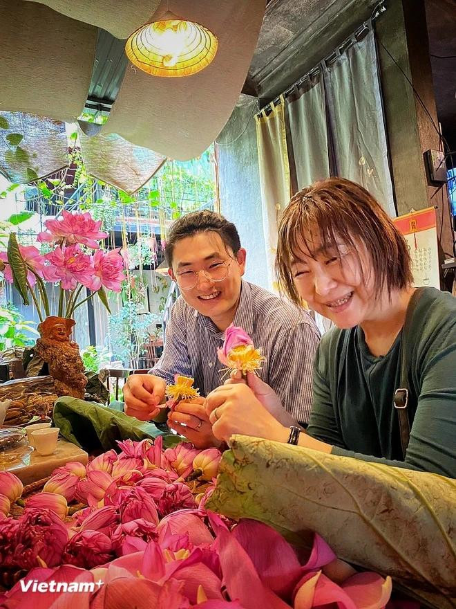 Des touristes japonais préparent du thé parfumé au lotus en suivant les instructions des artisans hanoïens. Photo : VietnamPlus tay-ho-lotus-4-2801.jpg.webp