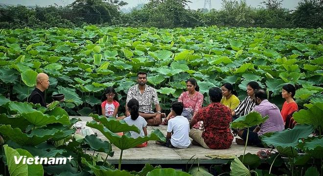Un groupe de touristes indiens expérimente une méditation autour du thé au lotus dans l'étang de Bach Diep. Photo : VietnamPlus tay-ho-lotus-3-1454.jpg.webp