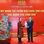Le président de l'Assemblée nationale, Tran Thanh Man, remet un cadeau à l'artisan Bui Van Tu. Photo : VNA