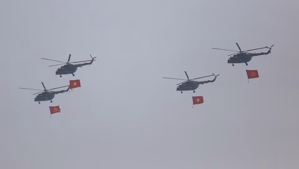 Les hélicoptères arborant le drapeau du Parti et le drapeau national volent en formation 3-4-3. Photo : VNA