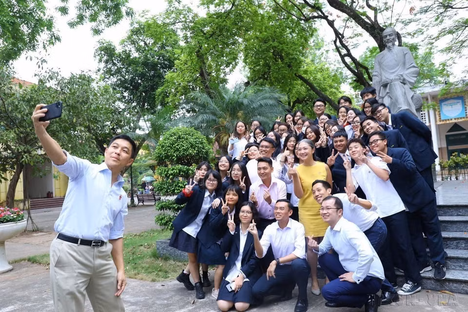 Le président du Parlement singapourien, Tan Chuan-Jin, prend un selfie avec des étudiants devant la statue de l'enseignant Chu Van An sur le campus du lycée Chu Van An (Hanoï, 19 mai 2022). Photo : Van Diep - VNA