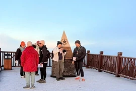 Plusieurs touristes sont ravis de découvrir la glace au sommet du mont Fansipan. Photo : VNA
