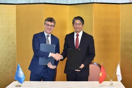 Le représentant en chef de l’UNESCO au Vietnam, Jonathan Wallace Baker (à gauche), et l'ambassadeur du Japon au Vietnam, Ito Naoki, lors de la cérémonie de signature. Photo: VNA