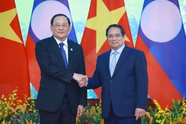 Le Premier ministre Pham Minh Chinh (droite) rencontre son homologue lao à l’occasion du Sommet du P4G à Hanoï. Photo: VNA