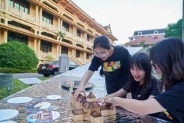 Des jeunes interagissent avec des œuvres d'art au Musée national d'histoire lors du Festival de design créatif de Hanoï 2024. Photo : VNA