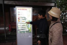 Des touristes utilisent un kiosque interactif au temple öng Hoàng Muoi dans la province de Nghe An. Photo: VNA