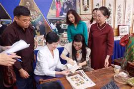 L'épouse du Premier ministre Pham Minh Chinh, Lê Thi Bich Trân et des membres de l'AWCH assistent à la fabrication de peintures folkloriques Dông Hô. Photo: VNA