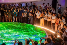 Le plan directeur de la capitale Hanoï à l’horizon de 100 ans est présenté à travers une maquette combinée à la technologie de projection mapping 3D, offrant une vue dynamique et visuelle au public depuis l'après-midi du 29 juin. Photo: VietnamPlus