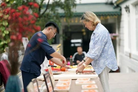 Pour les visiteurs étrangers présents au Vietnam à l'approche du Nouvel An lunaire, et notamment à Hanoï, s’immerger dans l’espace du Têt traditionnel est une expérience véritablement enrichissante. Photo: CTV/VietnamPlus