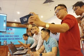 Des reporters de la VNA participe à une formation sur la production de vidéos . Photo : VNA