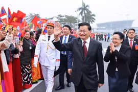 Le secrétaire général du PPRL et président du Laos, Thongloun Sisoulith et son épouse à l'aéroport international de Noi Bai. Photo: VNA