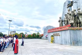 La délégation de jeunes Vietnamiens d’outre-mer devant le monument dédié au Président Hô Chi Minh et aux populations de Quang Binh. Photo: VNA