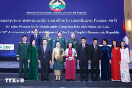 Des responsables vietnamiens et lao au banquet en l'honneur du 50ᵉ anniversaire de la Fête nationale du Laos. Photo: VNA