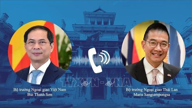 Les deux ministres des AE du Vietnam (gauche) et de la Thaïlande s’entretiennent au téléphone. Photo: VNA