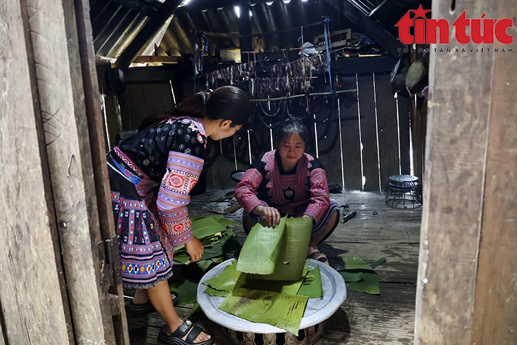 Des femmes préparent des feuilles de bananier chauffées au feu et nettoyées. Photo: VNA