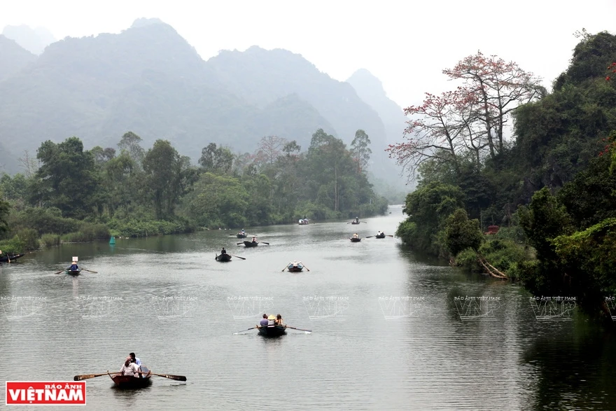 Touristes en barques sur la rivière Yên menant à la pagode des Parfums.