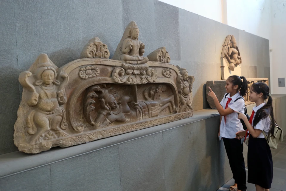 Elèves de Da Nang examinant le bas-relief "Naissance de Brahma", un Trésor national reconnu en 2024. Photo : VNA