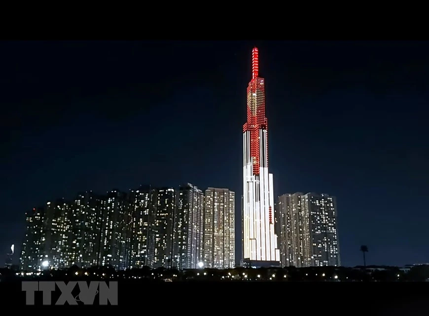  Le gratte-ciel Landmark 81, dans la rue Nguyen Huu Canh, arrondissement de Binh Thanh, avec le message ''Allumer le cœur - répandre l'amour, éradiquer le COVID-19''. Photo: VNA