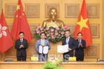 Le vice-Premier ministre Trân Luu Quang (à droite) et le chef de l'exécutif de la région administrative spéciale de Hong Kong, Lee Ka-chiu (à gauche) assistent à l'échange du protocole d'accord entre Vietnam Airlines et l'aéroport international de Hong Kong (HKIA). Photo : VNA