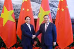 Le Premier ministre vietnamien Pham Minh Chinh (à gauche) et son homologue chinois Li Qiang se serrent la main, à Dalian, en Chine, le 24 juin. Photo: VNA