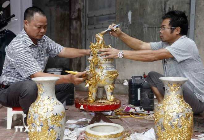 Produits en porcelaine plaquée or chez la famille de l'artisan Nguyên Anh Chung. Photo: VNA nguyen anh chung.webp