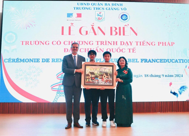 La directrice du collège Giang Vo, Tô Thi Hai Yên, et ses élèves remettent un cadeau à l'ambassadeur de France au Vietnam, Olivier Brochet. Photo : CTV/CVN cadeau à l'ambassadeur.jpg