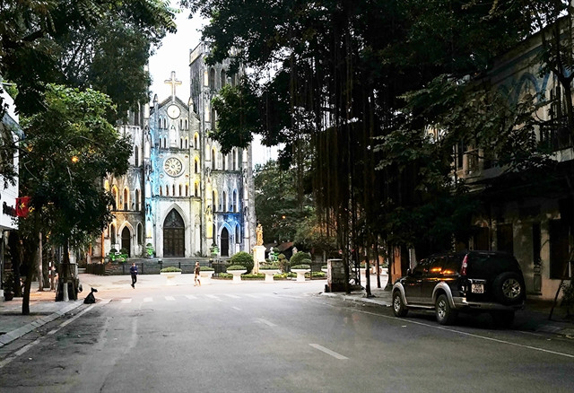 La cathédrale historique Saint-Joseph et les maisons de style français voisines encadrent une scène où la végétation luxuriante et les racines des arbres tissent une tapisserie romantique. Photo mia.vn cathédrale st joseph.jpg