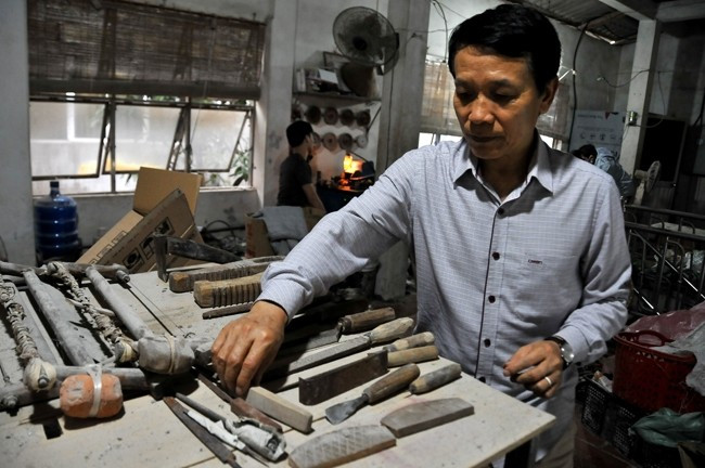 Fabrication de peignes en corne, une tradition ancestrale dans ce village. Photo: dangcongsan.vn Fabrication de peignes en corne.jpg
