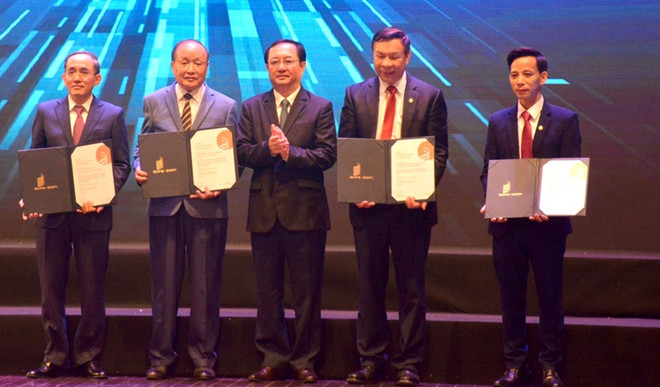 Le ministre de la Science et de la Technologie Huynh Thành Dat (au centre) décerne le prix au groupe d'auteurs de deux ouvrages. Huynh Thanh Dat.jpg