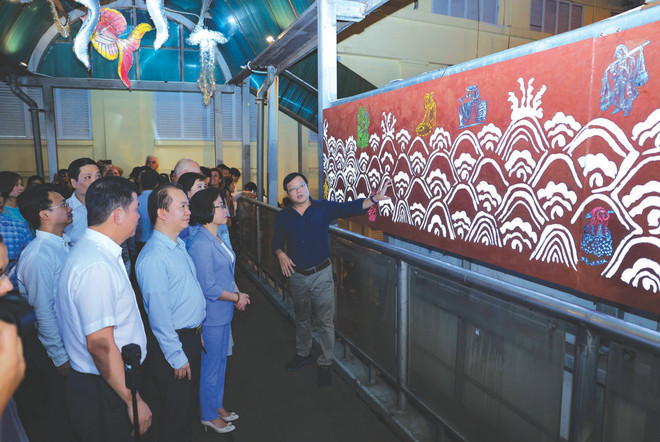 L’artiste Nguyên Thê Son présente une œuvre du projet de pont piétonnier artistique de la rue Trân Nhât Duât à Hanoï. Photo : VNA Trân Nhât Duât.jpg
