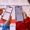 De jeunes électeurs consultent les profils des candidats sur l’application VNeID. Photo: VNA