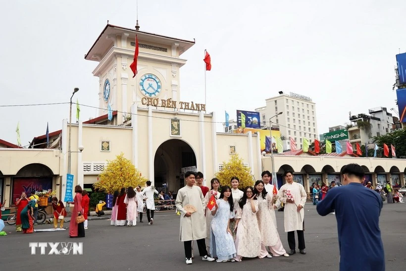 Des habitants et des touristes prennent des photos souvenirs au marché Ben Thanh. Photo : VNA.