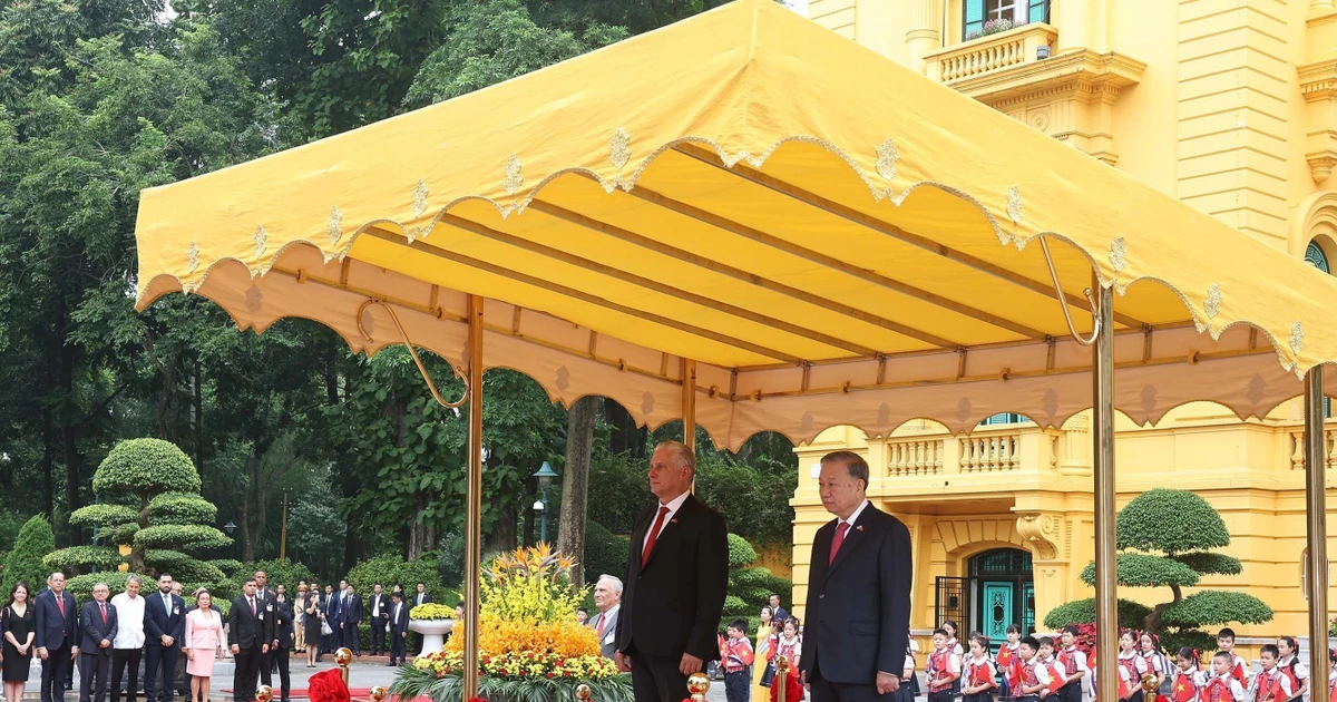 Le Secrétaire général du PCV To Lam (à droite) et le Premier secrétaire et président cubain Miguel Díaz-Canel Bermúdez à la tribune, écoutant la fanfare militaire jouer les hymnes nationaux des deux pays. Photo : VNA.