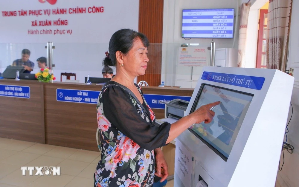 Une femme venue pour effectuer les démarches administratives au Centre de services de l'administration publique de la commune de Xuan Hong, à Ninh Binh. Photo : VNA 