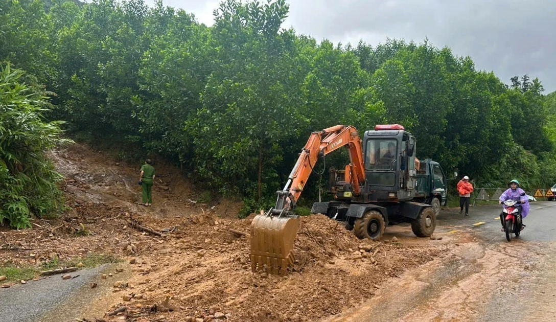 Les forces compétentes dégagent l’emplacement éboulé sur la route nationale 14G, commune de Hoa Vang, à Da Nang. Photo : VNA.