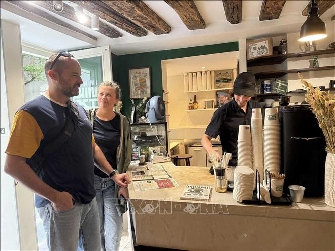 Des Français se rendent chez “PHIN MI” pour déguster un café aux saveurs typiquement vietnamiennes. Photo : VNA.
