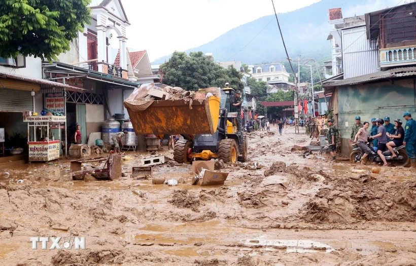 Des excavatrices aident à ramasser la boue, les branches d'arbres et les déchets emportés par les récentes inondations dans la commune de Song Ma, province de Son La. Photo : VNA