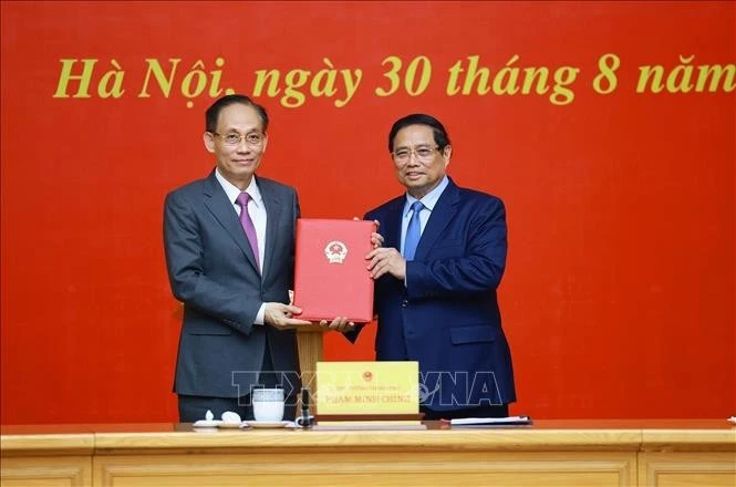 Le Premier ministre Pham Minh Chinh (droite) remet à Le Hoai Trung la décision concernant sa nomination au poste de ministre par intérim des Affaires étrangères. Photo: VNA 