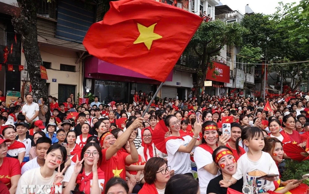 Des habitants attendent dans des rues de Hanoï pour assister à la répétition générale du défilé pour le 2 septembre. Photo: VNA
