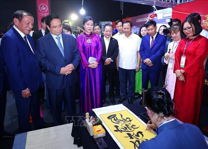 Le Premier ministre Pham Minh Chinh visite un stand vietnamien lors de l'événement. Photo : VNA. 