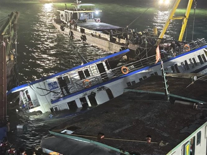 Le bateau touristique Vinh Xanh 58, qui a chaviré, a été récupéré et remorqué jusqu'à la côte le 20 juillet pour une enquête plus approfondie. Photo : VNA. 
