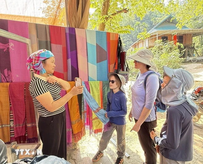 Les textiles en brocart fabriqués artisanalement par les habitants du village de Lan Ngoai sont très appréciés des touristes. Photo : VNA. 
