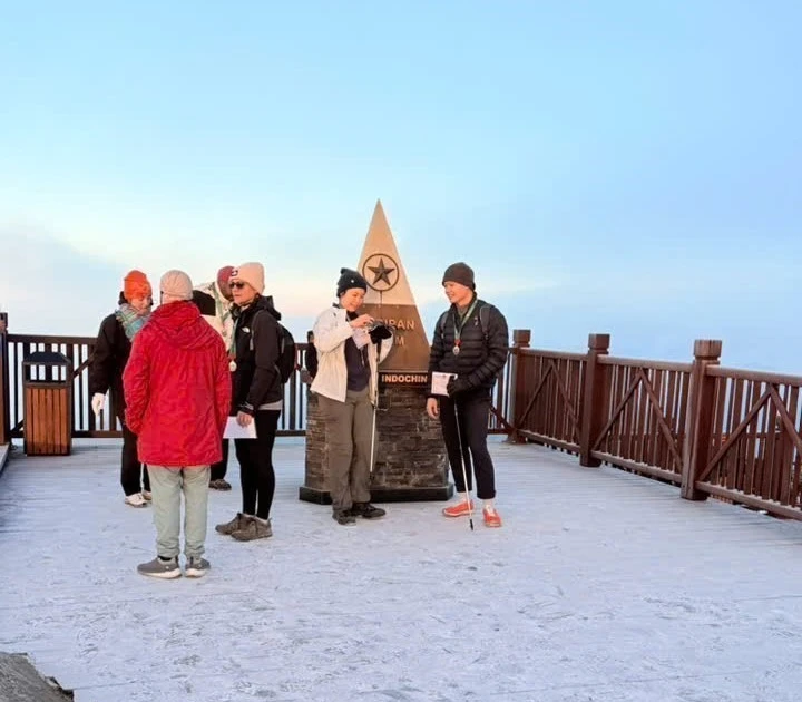 Les touristes sont ravis de découvrir la glace au sommet du mont Fansipan. Photo : VNA. 