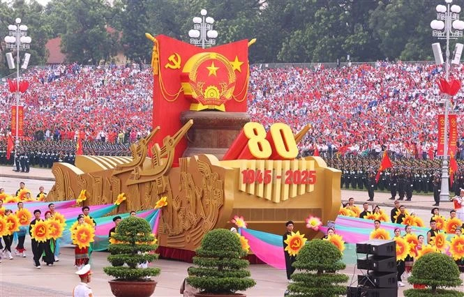 Un véhicule miniature portant l'emblème national de la République socialiste du Vietnam mène le défilé militaire et le cortège de masse. Photo : VNA.