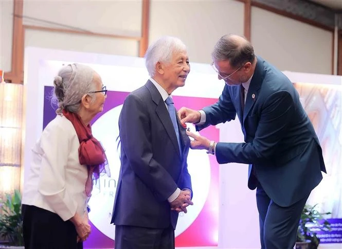 L’ambassadeur de France au Vietnam, Olivier Brochet, remet la distinction au professeur Trân Thanh Vân et à la professeure Lê Kim Ngoc, à Hanoi, le 4 octobre. Photo : VNA