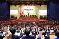 Les délégués votent l'adoption de la Résolution du 14e Congrès national du Parti communiste vietnamien. (Photo : VNA)